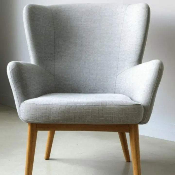 Nowoczesne krzesło o miękkiej tapicerce w neutralnym kolorze.